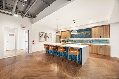 a kitchen with a large island with blue stools